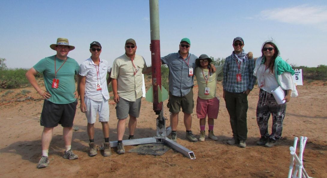 Students pose with rocket