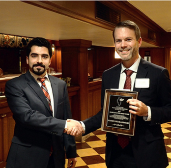 Ramin Shabanpour receives award plaque 
