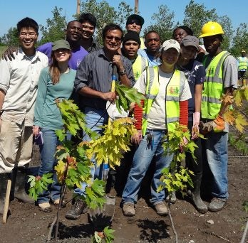 Professor Reddy planting trees with students 