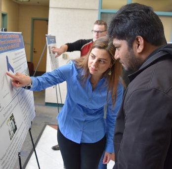Students observe posters at competition 