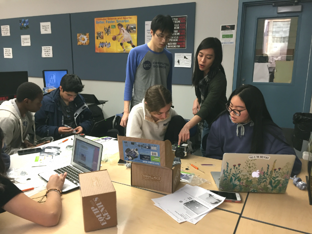 Chen (standing, left) and Tse (standing, right) behind seated students at Jones Prep