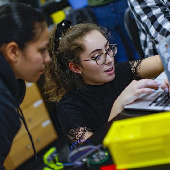 Two students collaborating at a laptop