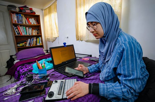 Dua Shehadeh works in her bedroom at home, performing testing procedures for consumer devices