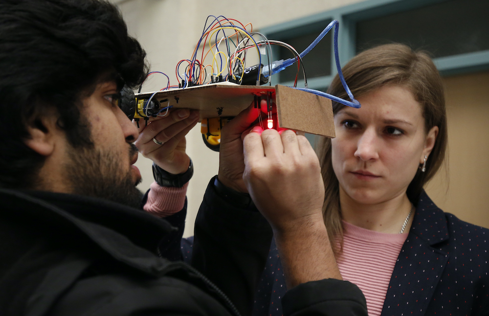 two students collaborate on a miniature autonomous car project