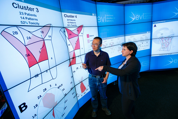 Liz Marai and CS assistant professor Xinhua Zhang look at a graphic showing the patterns of disease spread through the lymph nodes, across a population of head and neck cancer patients in Chicago
