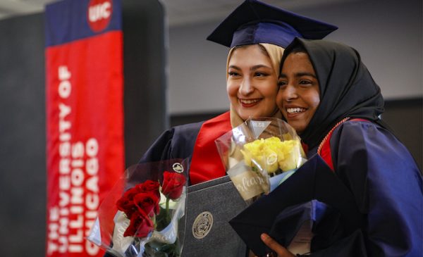 two female students embrace after their graduation ceremony at UIC