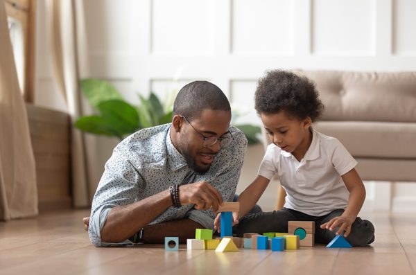 A caregiver and child playing with blocks