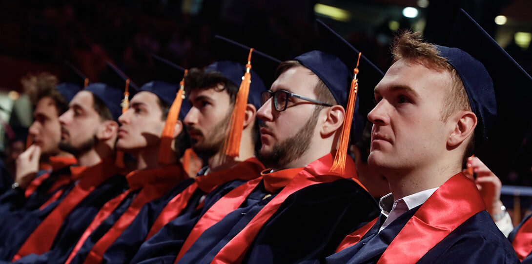 row of graduates waiting to get diplomas