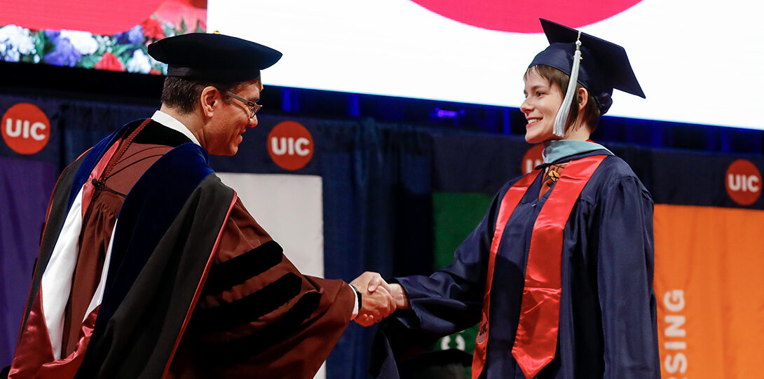 Graduate shakes hand with Intewrim Chancellor on stage