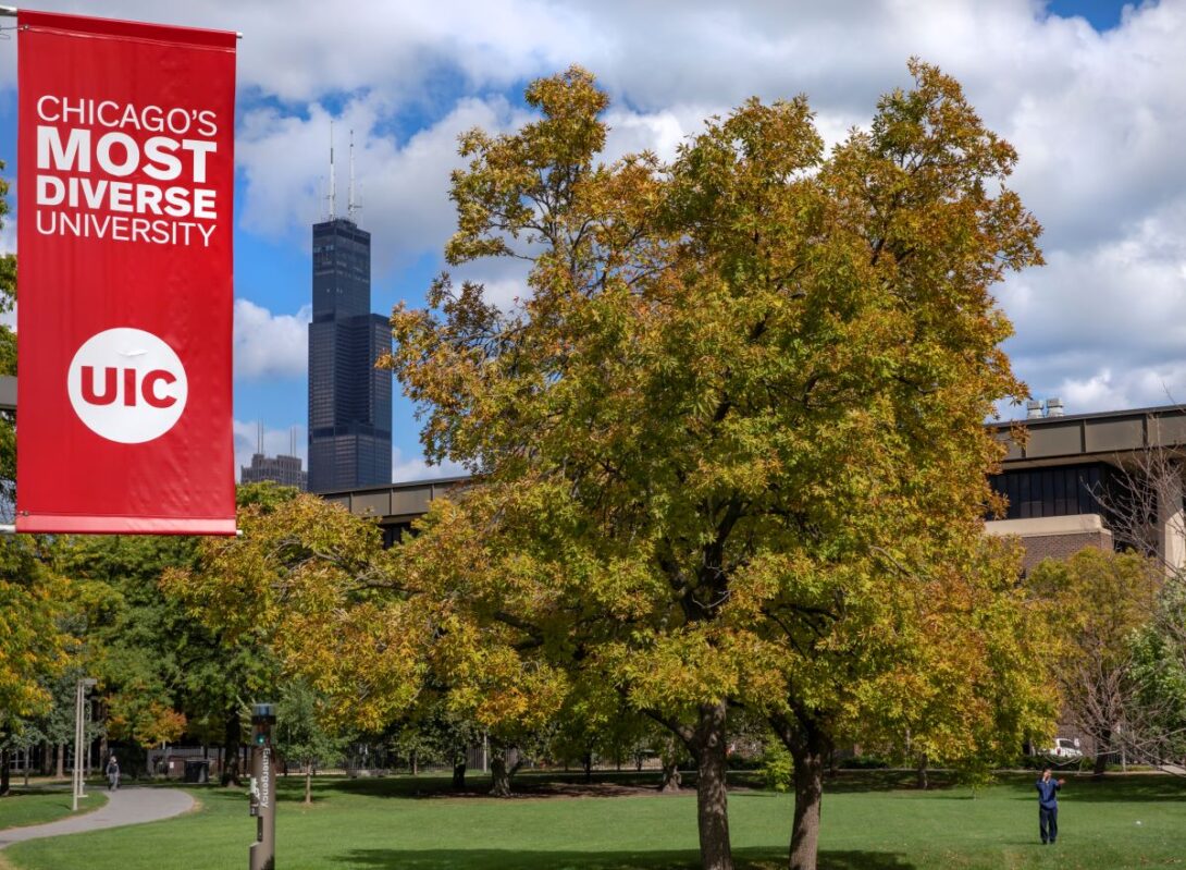 Image of a tree and the Willis Tower on campus with a sign saying UIC is Chicago's most diverse university.