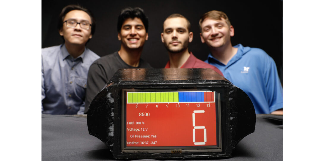 students pose with display panel