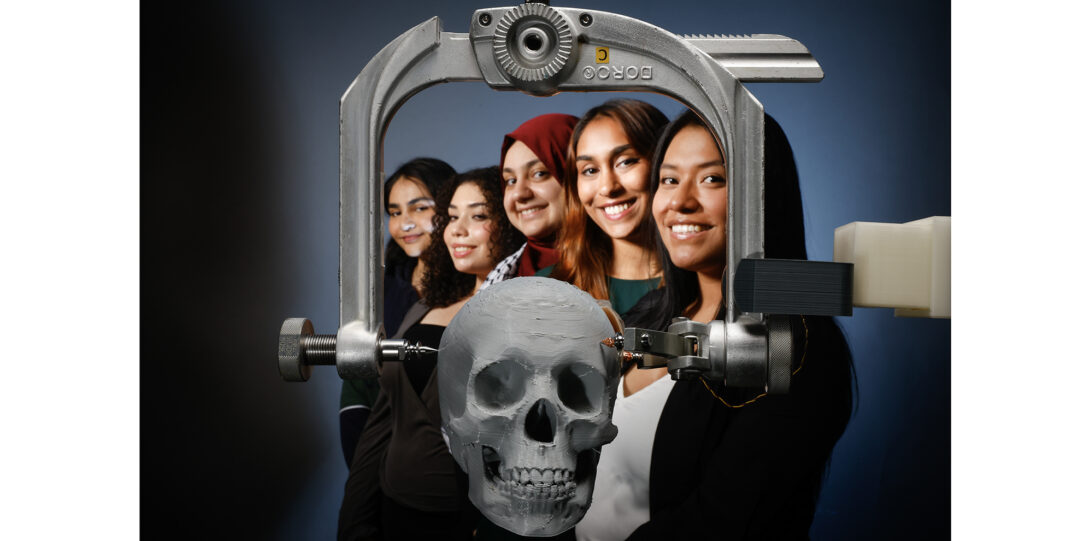 students photographed with medical clamp device and 3D printed head