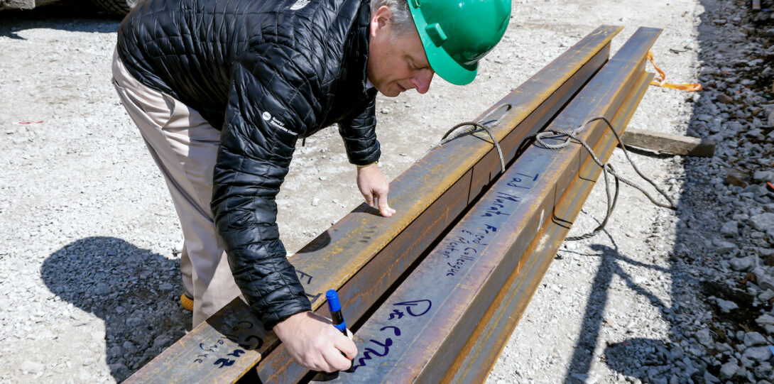 Dean Pete Nelson signs the final structural beam used in the CDRLC building construction