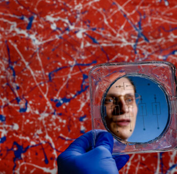 University of Illinois Chicago College of Engineering PhD student Michael Rogy reflected in a Microfluidic mold. Rogy won an NSF graduate fellowship.
                  
