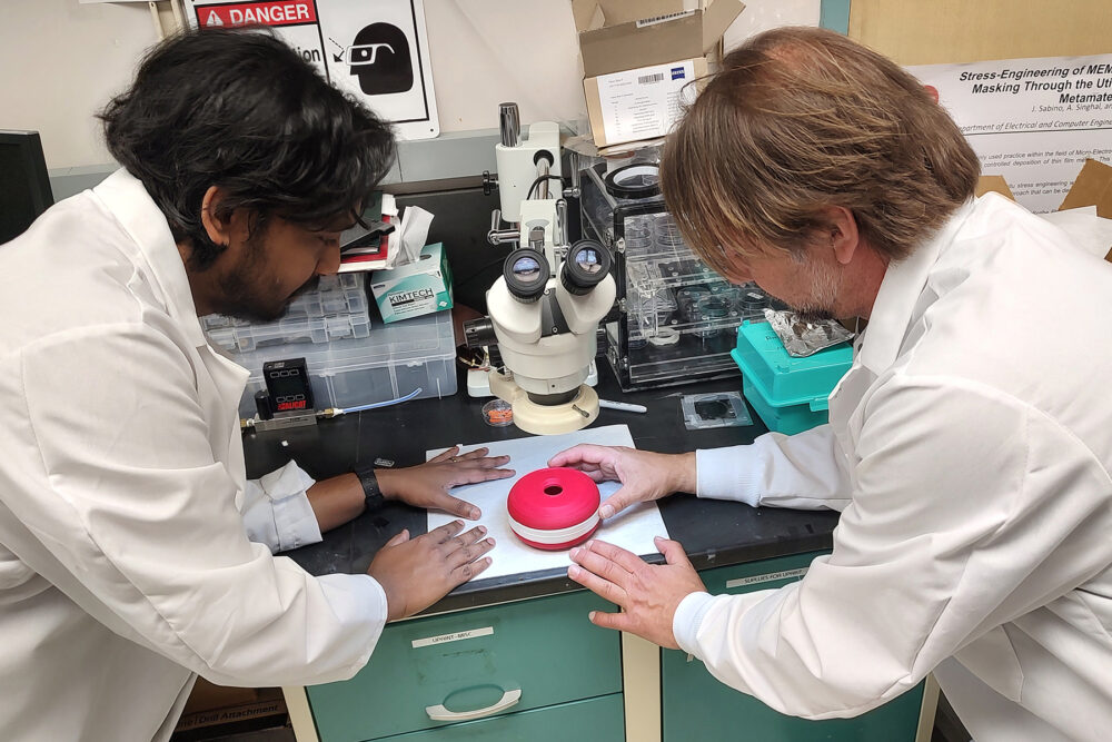 Nitin Jayakumar (left) and Igor Paprotny work on a prototype of their device for detecting airborne virus particles.