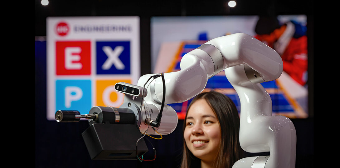 student photographed with robotic arm