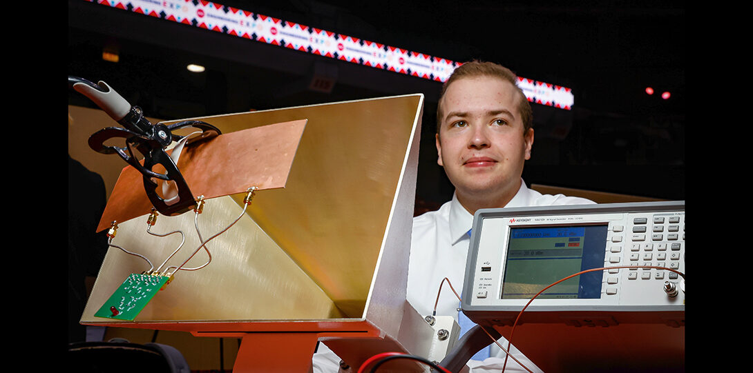student photographed with antennae and electronics equipment