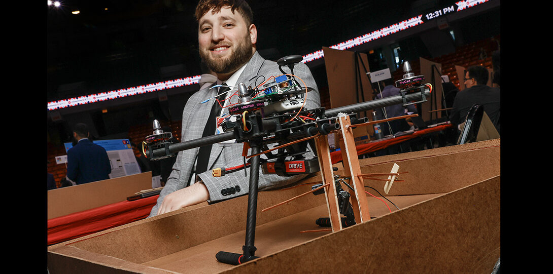 student poses with drone