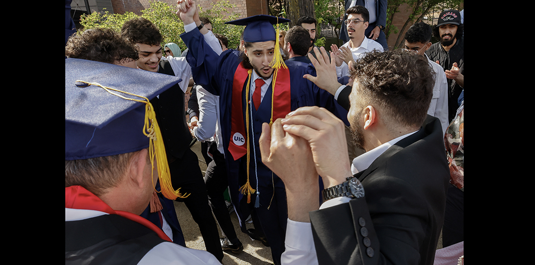 graduates dance in teh street with family and friends