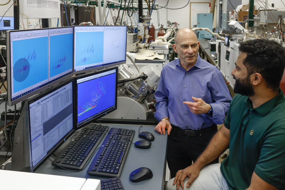 Professor Kenneth Brezinsky, left, speaks with graduate student Jerry Chethalan about analyzing fuel composition.