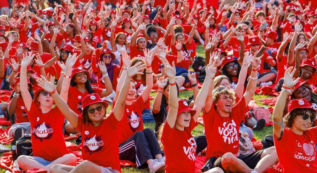 Students sitting on the grass at convocation 2024