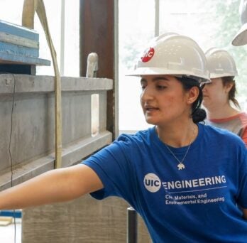 Student inspects damage to a concrete beam
                  