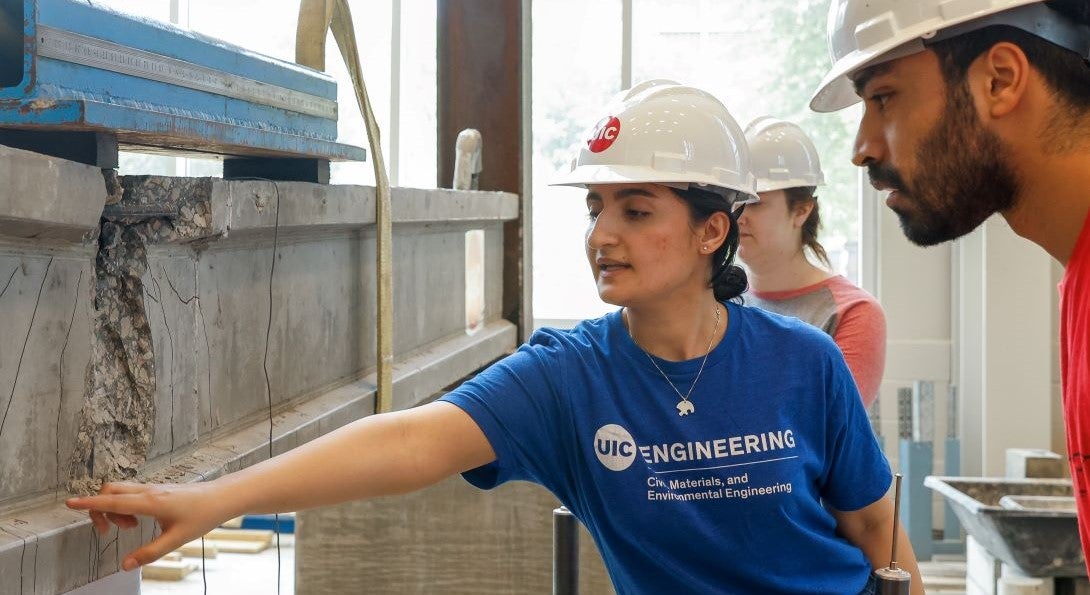 Student inspects damage to a concrete beam