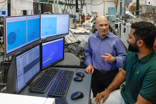 MIE professor Kenneth Brezinsky speaks with graduate student Jerry Chethalan abut analyzing fuel composition.