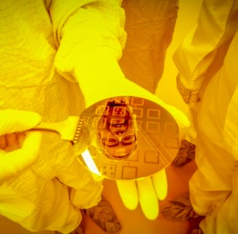 researcher reflected in a silicon wafer 