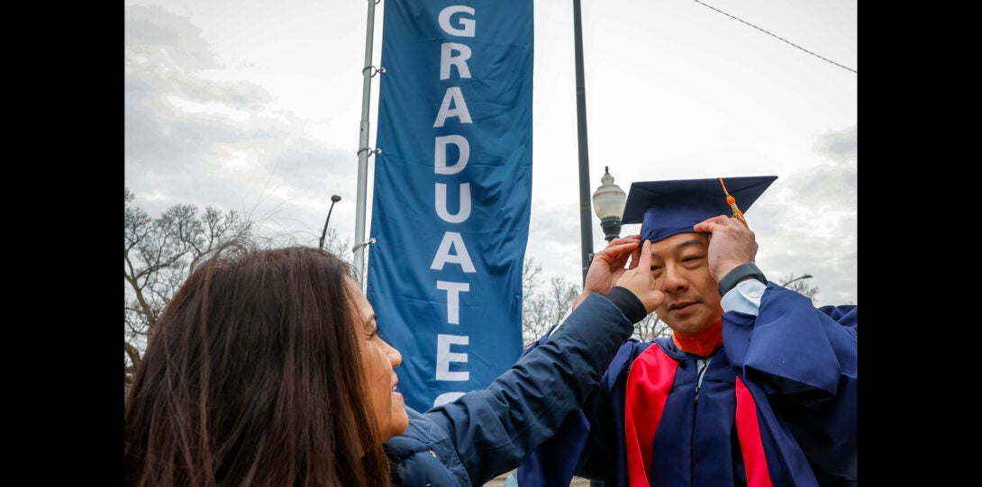 family member helping student with cap