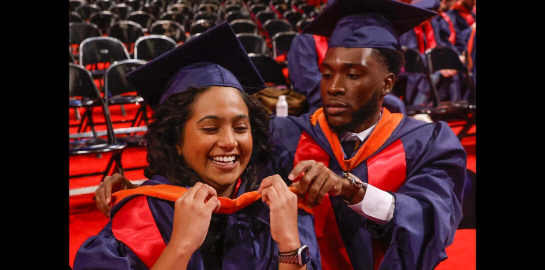 fellow student helping another student with gown