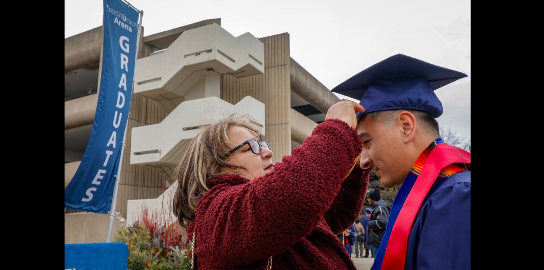 family member fixing the cap of a student