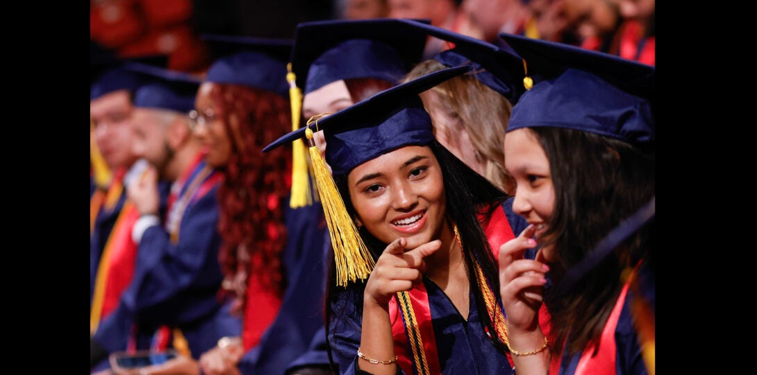 graduating student poses for photos in the crowd