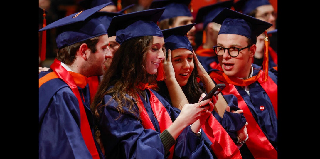 a row of students looking at their phone