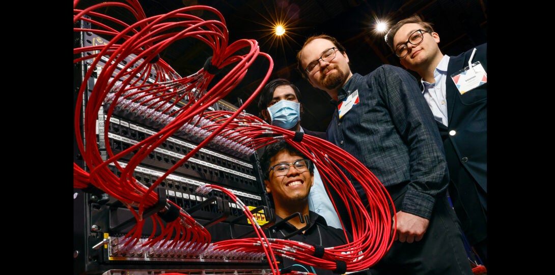 group of students pose for a photo with cables attached to their design project