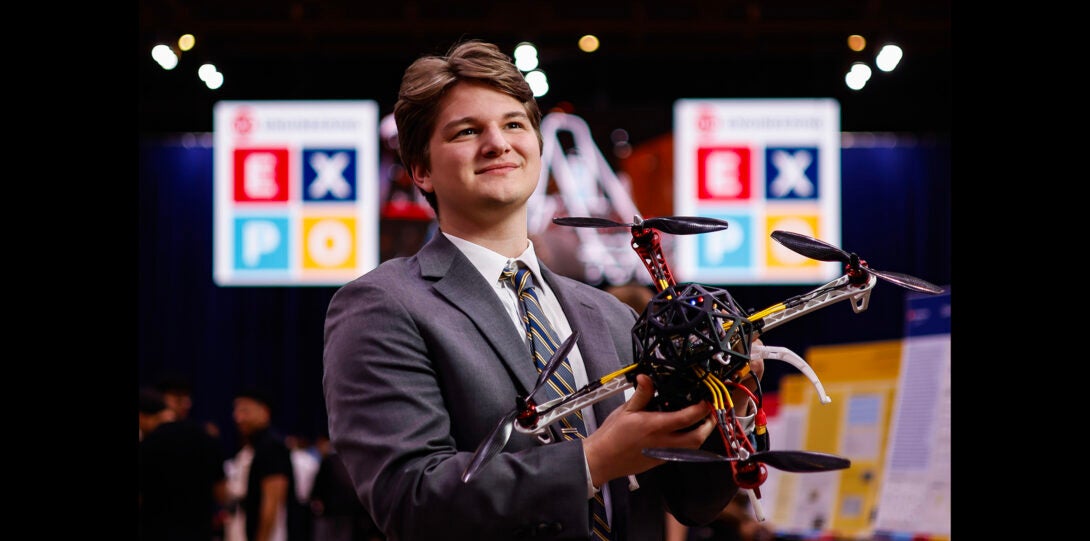 student poses with drone