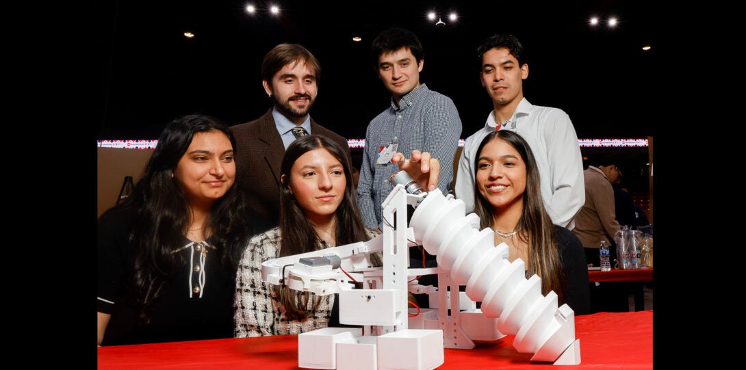 students pose with project that separates ball bearings