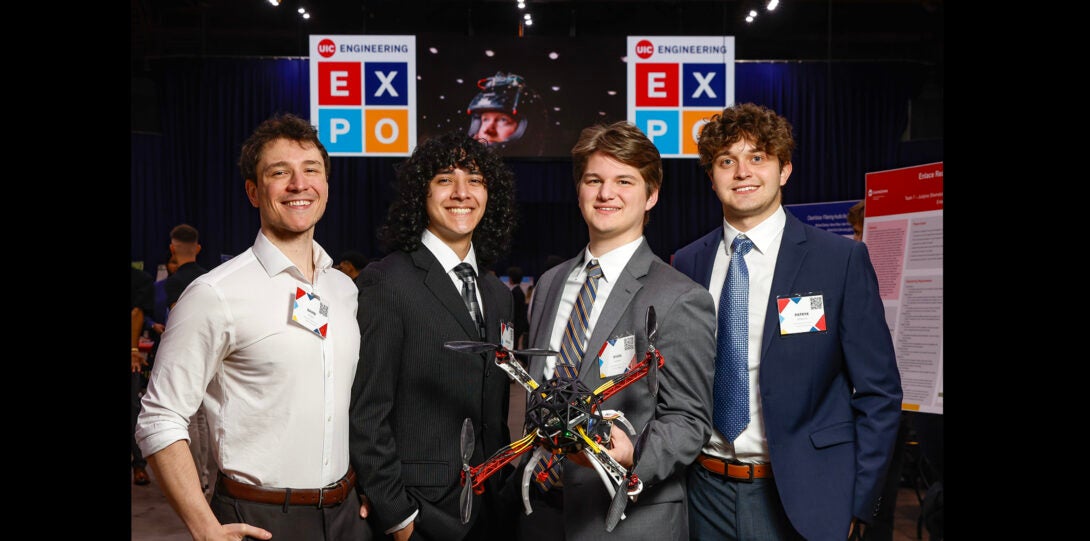 group of students pose for photo with a drone