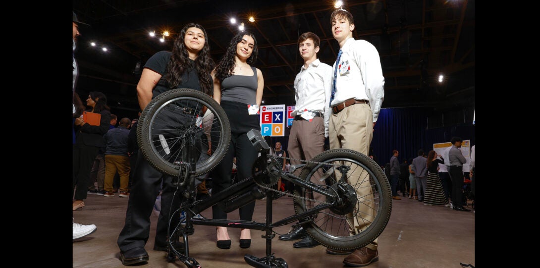group of students pose with bicycle using special pedals