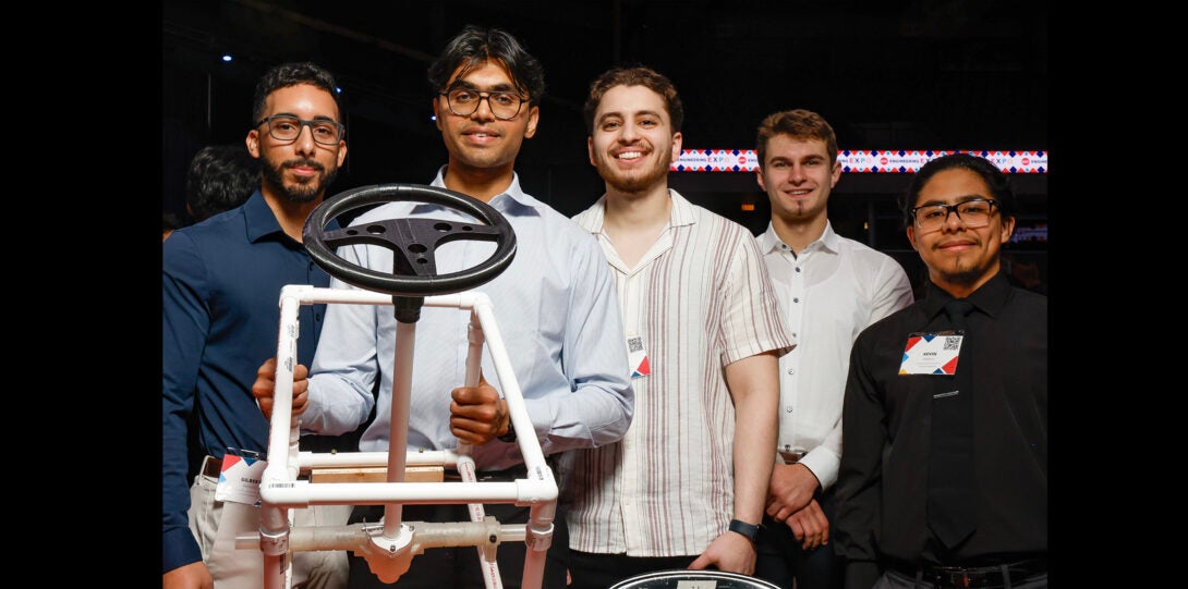 group of students pose with steering wheel research project