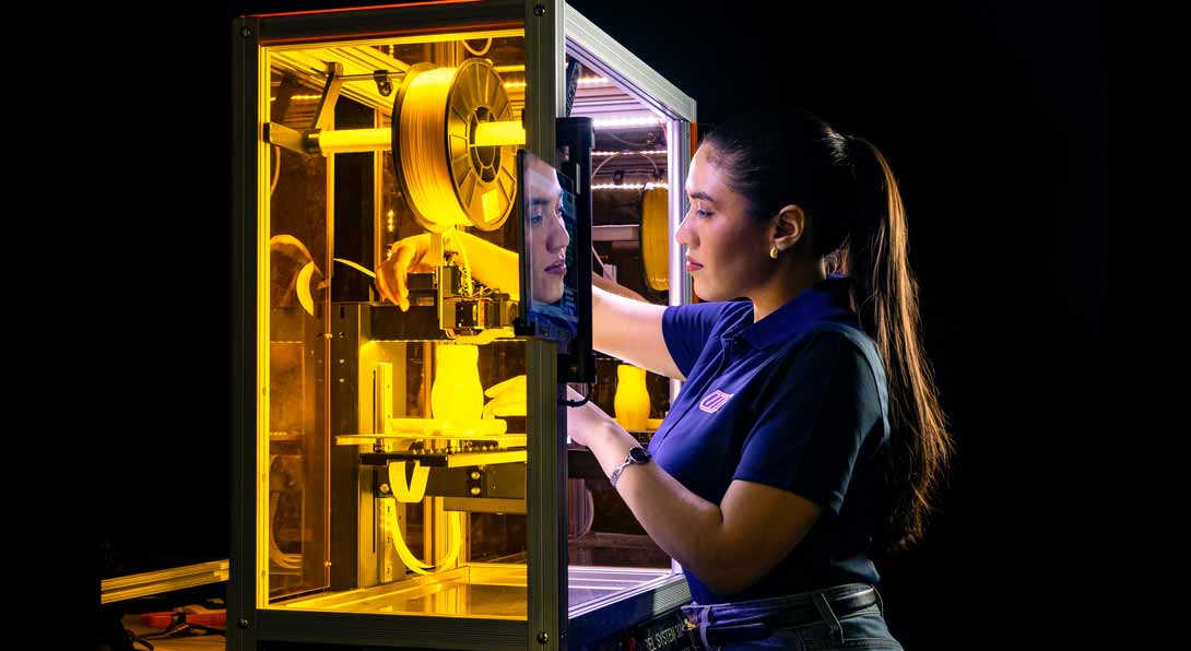 Student Lucia Valenzuela Sandoval with a fused deposition modeling 3D printing machine in professor Lin Le’s lab