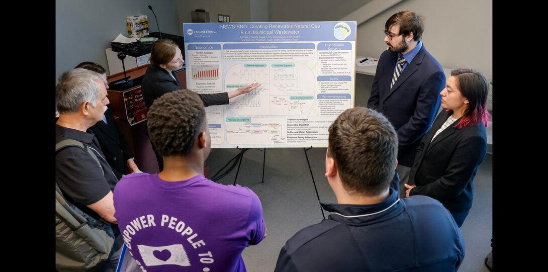 a group of students explain their project poster to judges